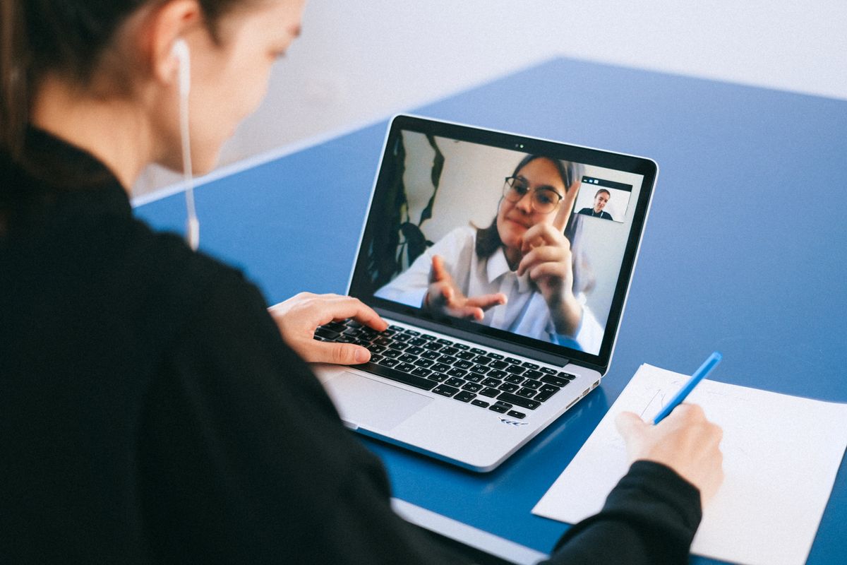 Une cliente échange en
    visioconférence avec sa consultante sur son ordinateur portable, en prenant des notes